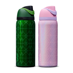 Owala Wicked 32oz FreeSip bundle showing two bottles side by side — deep emerald green Elphaba edition with geometric diamond-pattern texture and dark green flip cap, and shimmery iridescent lavender-pink Glinda edition with pink flip cap